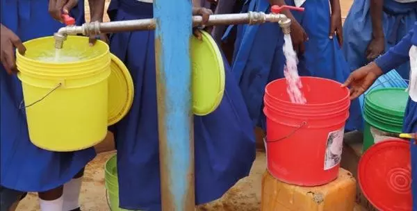 Pupils collect water at a school